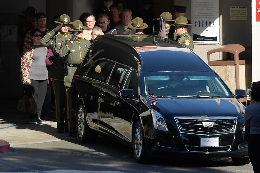 An honor guard salutes the body of Sgt. Ron Helus before it departs the Los Robles Regional Medical Center Thursday, Nov. 8, 2018, in Thousand Oaks, Calif. Helus was killed after a gunman opened fire the night before inside a country dance bar crowded with hundreds of people.