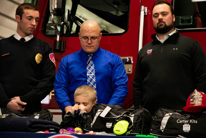 From left, Saginaw firefighter Brandon Hausbeck, Saginaw Township Police Detective Justin Severs and his son Carter, 5, and Andrew Keller stand together during a press conference unveiling the new Carter Kits at Saginaw Fire Department Station #1 on Thursday, Dec. 12, 2019.