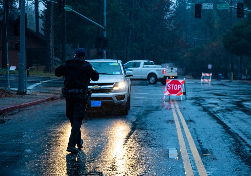Paradise Police Officer Perry Walters assists a PG&E worker who's trying to get around many of the street closures on Nov. 27, 2018 in Paradise, Calif. 