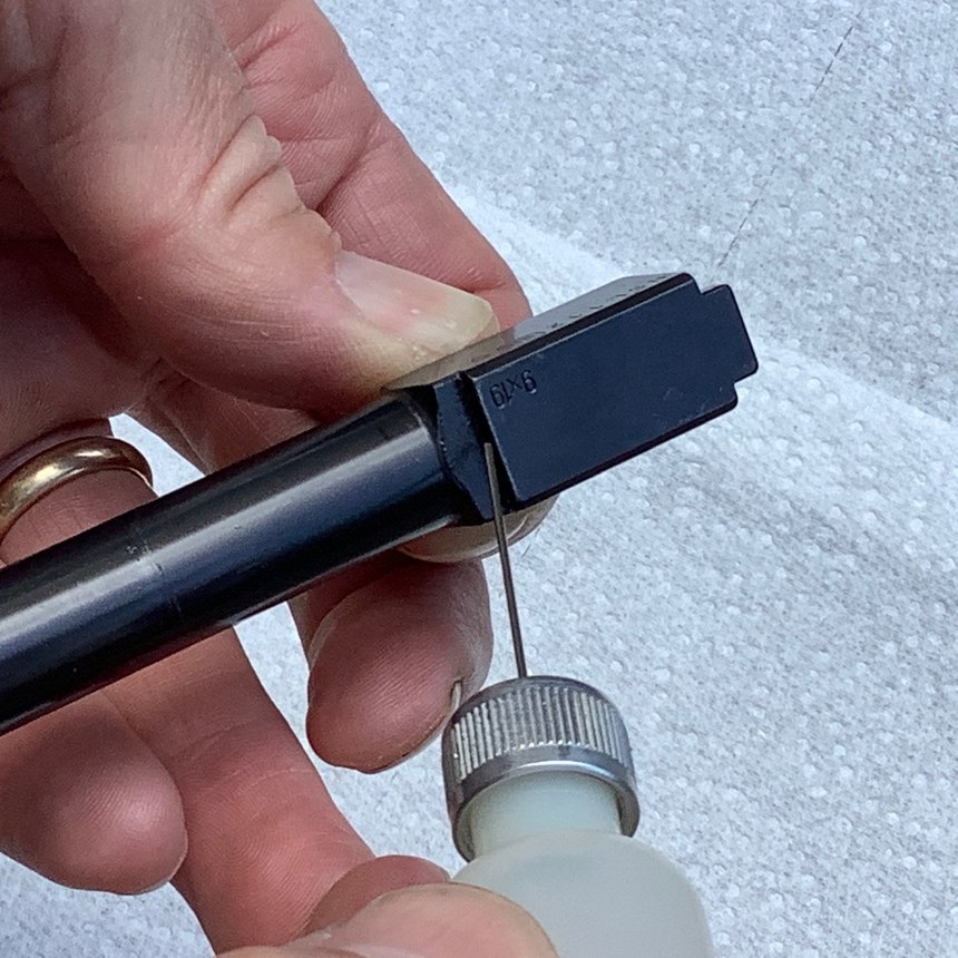 Place a small drop of oil where the hood of the barrel locks into the slide and smear it around with your finger.