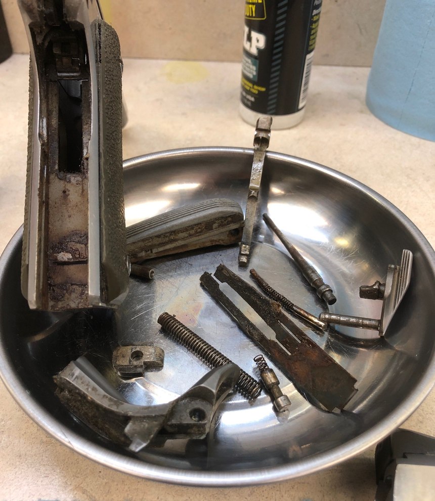 This 1911 pistol was so neglected that it had to be hammered apart to gain access to the internals.