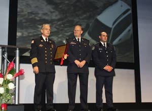 Photo Jamie ThompsonCaptain Kendall Thompson (right) stands alongside NSW Assistant Commissioner Keith Harrap, as IAFC President Jack Perow prepares to hand over the award.