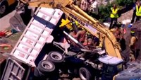 Firefighters extricate driver pinned in crushed truck