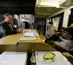 Warden Ronald Davis, left, talks with guards on duty in the east block of death row at San Quentin State Prison Tuesday, Aug. 16, 2016, in San Quentin, Calif.