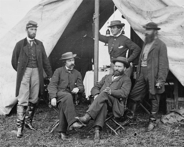 In this photo, Allan Pinkerton is sitting on the right. It is believed the person standing directly behind him is Kate Warne.